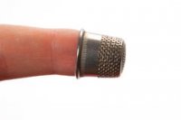 thimble-middle-finger-closeup-white-46034444.jpg