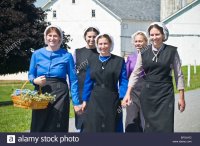 young-amish-women-friends-walking-down-country-lane-road-in-lancaster-BFGAYD.jpg