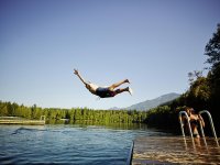 man-diving-off-dock-into-mountain-lake-thomas-barwick.jpg