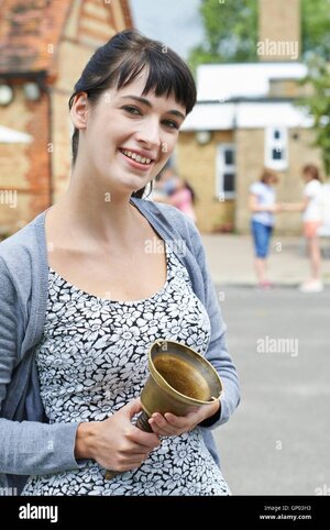 portrait-of-teacher-with-bell-supervising-break-in-school-playground-GP03H3.jpg