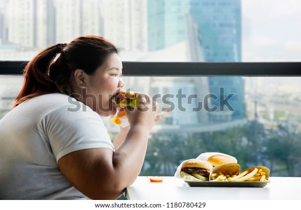 picture-fat-woman-eating-hamburger-600w-1180780429.jpg